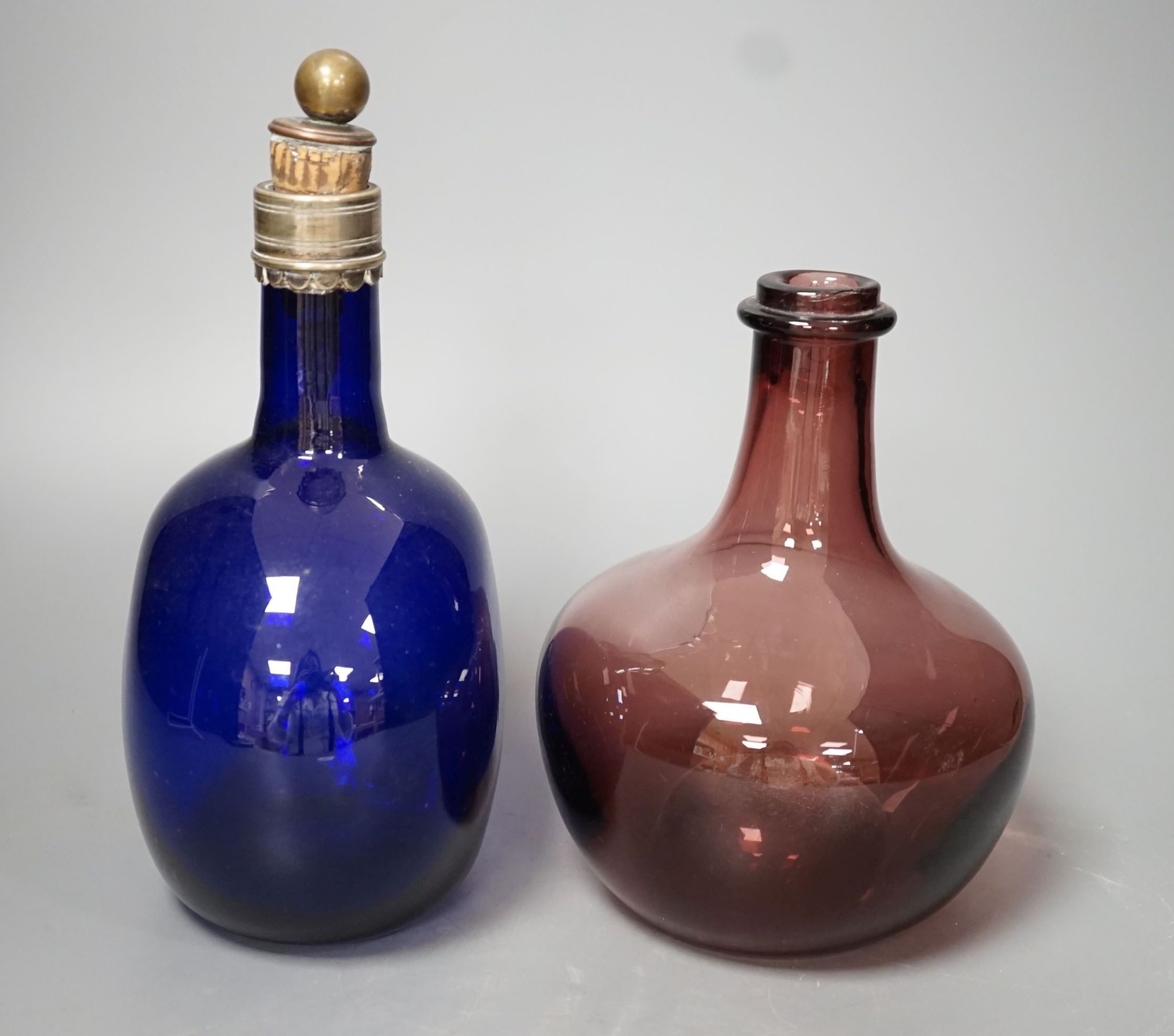 A Victorian blue glass claret jug and an amethyst glass bottle, tallest 23cm